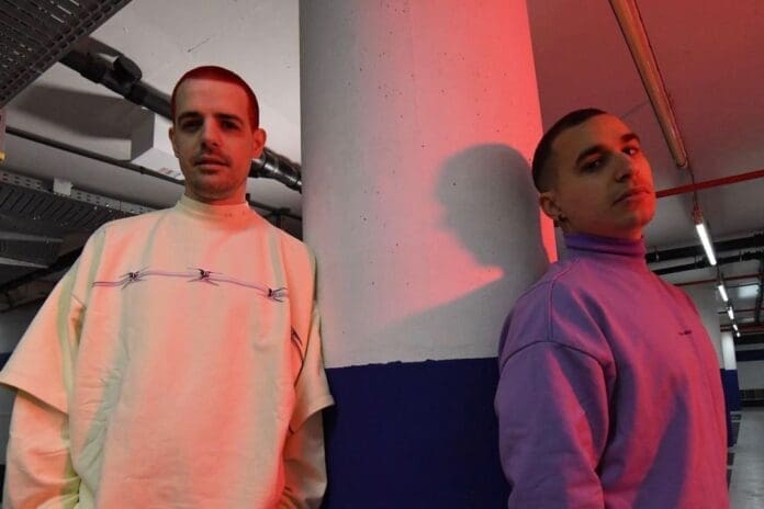 Two men in a parking garage.