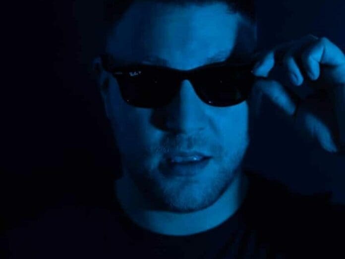 Cody Chase unveils his new single 'Supernova' while wearing sunglasses in a dark room.