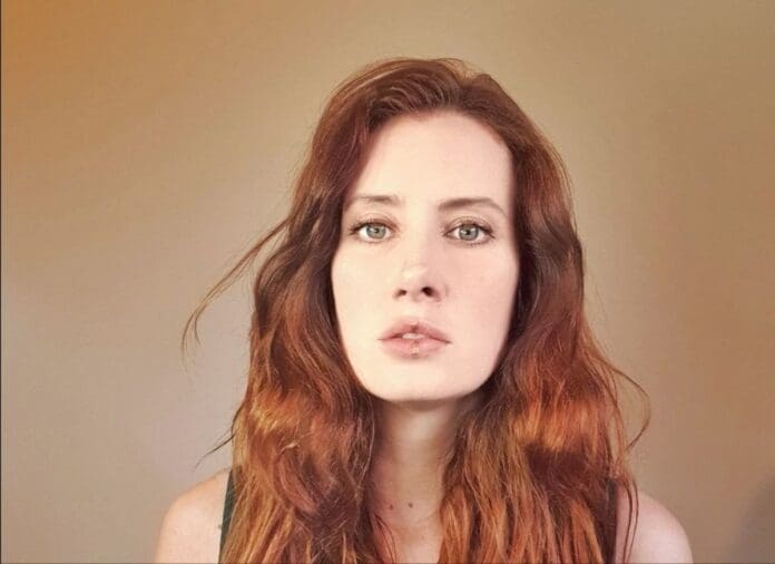 A woman with long red hair unveils her debut photo.