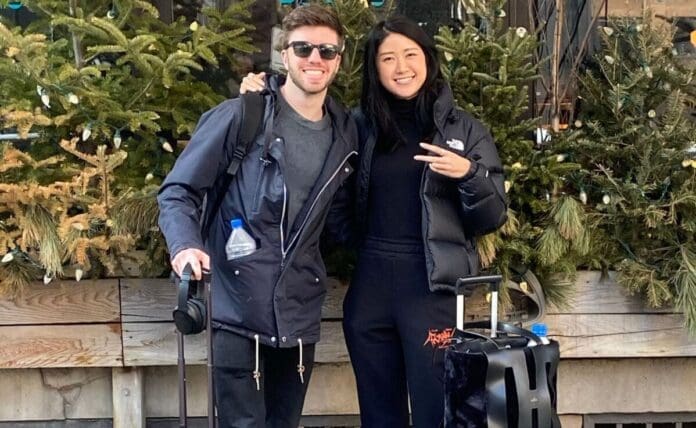 A man and woman posing in front of a tree with luggage for Spencer Brown And QRION's new single 