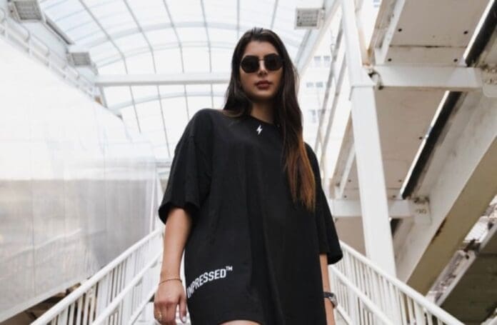 Amal Nemer debuts on Farris Wheel wearing a black t-shirt dress and sunglasses.