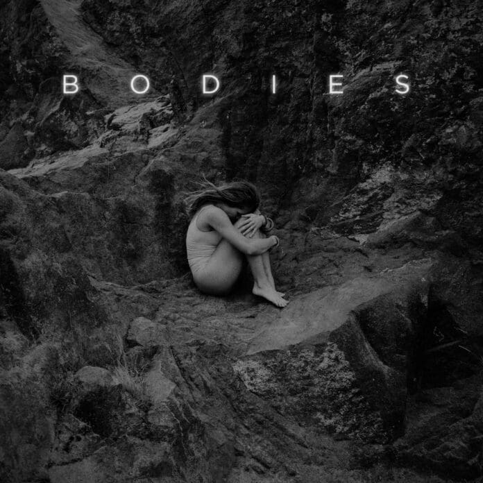 An image of a woman sitting on rocks with the word 'Bodies'.