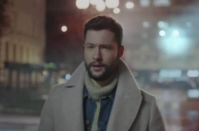 A man standing in a city at night.