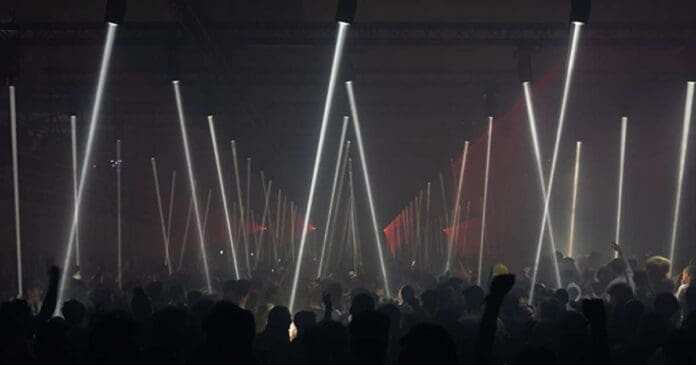 A group of people in a dark room with light beams at Brussels' Horst Arts and Music festival.