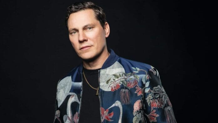 A man posing in a floral jacket against a black background, Tiësto remixes Ferry Corsten classic ‘Punk.’