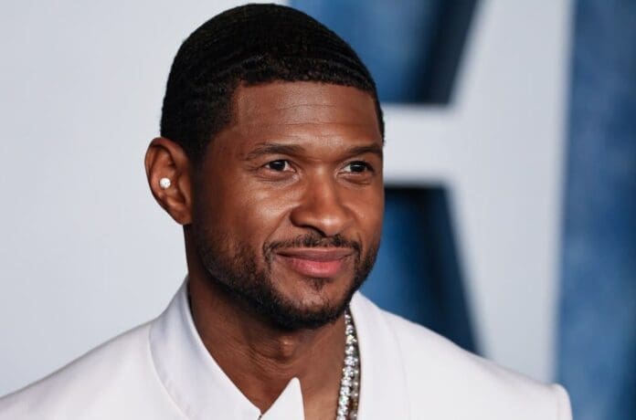 A black man, white jacket, necklace.