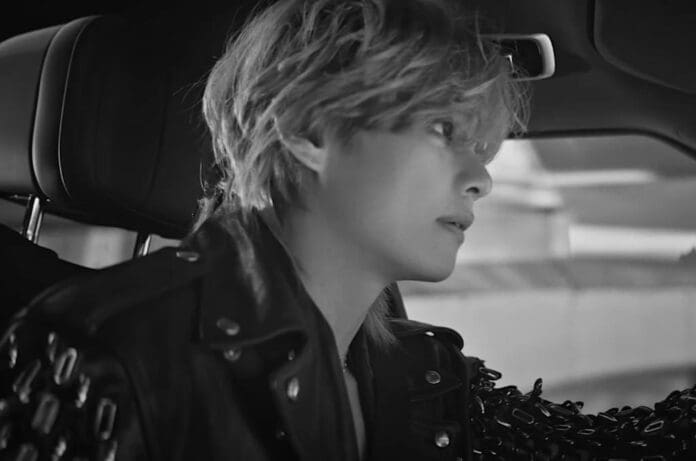 A black and white photo of a man sitting in a car featuring BTS' V.