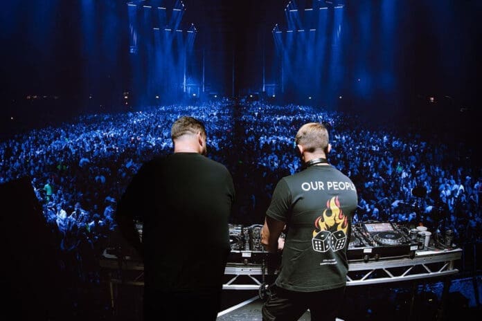 Two DJs debut long-awaited album on stage in front of audience.