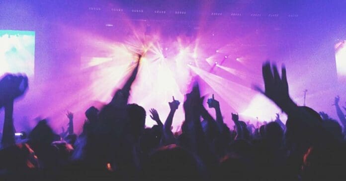 A concert crowd with raised hands.