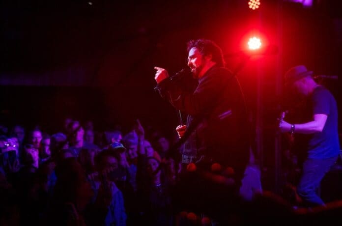 A man singing on stage during Adam Duritz's Eras Tour.