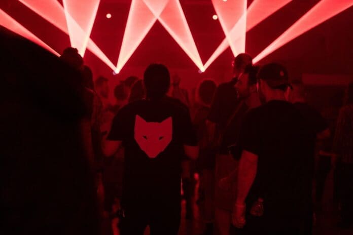 A group of people standing in a dark room with red lights at Darkside III by the Mystics of Shadow Wulf and Soulestial Carnival.