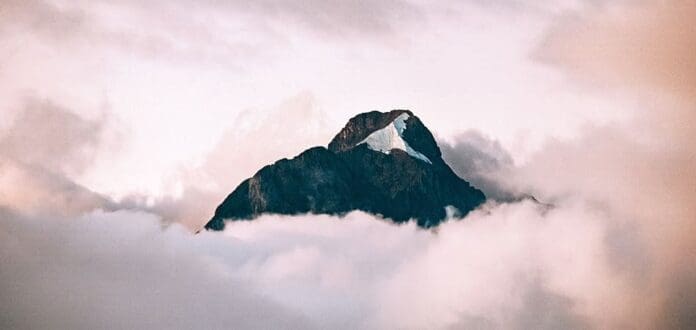 A mountain peak viewed amidst clouds while enjoying Oritsé Williams' new song 