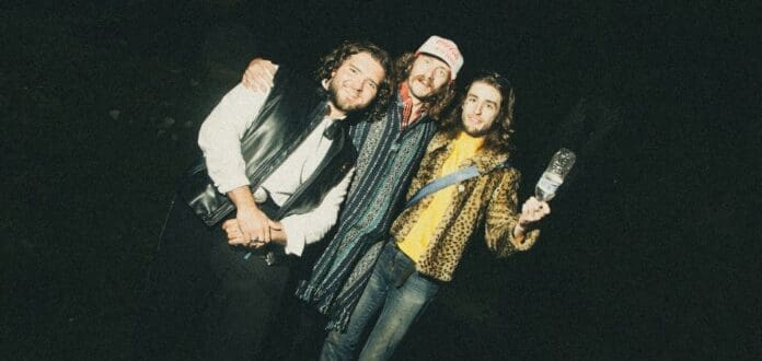 Three HIGH FADE men posing for a picture in the dark.