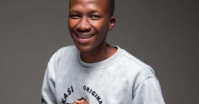 A young man in a grey t-shirt smiling at Amapiano DJs' pledge.