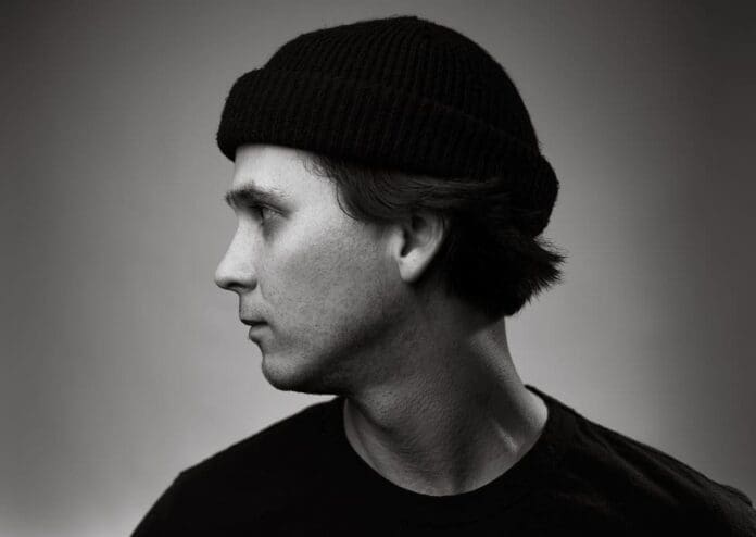 A monochrome picture of a man in a beanie.