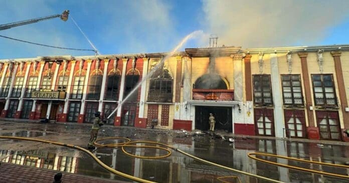 A firefighter is battling a building fire.