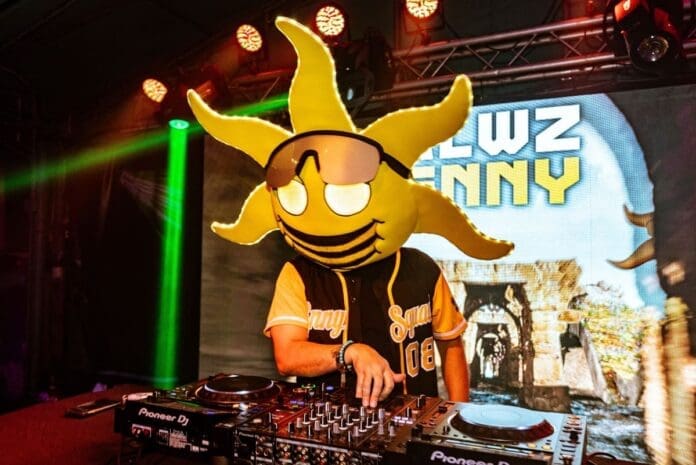 A man dressed as a DJ with a sun on his head, representing Insomniac's Discovery Project.