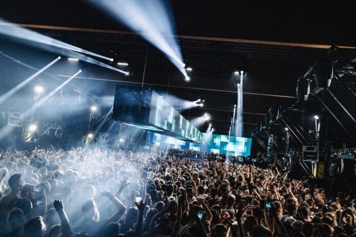 A crowd of people at a music festival at night experiences the debut U.S. events for Amsterdam's DGTL Festival in NYC and LA.