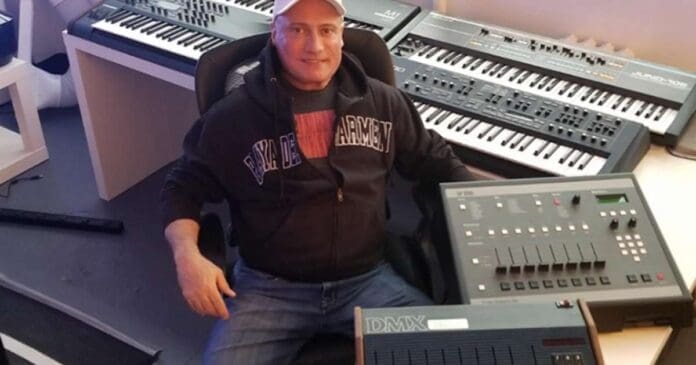 A man sitting in front of a keyboard and synthesizer, auctioning off rare DJ and production gear.