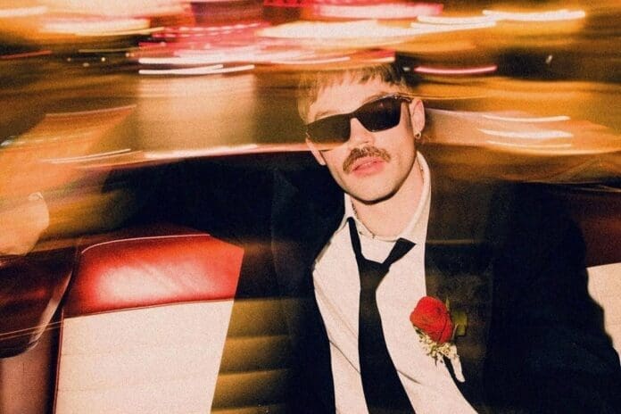 A man in a suit and tie saving up while sitting in a car.