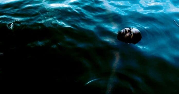 A man is swimming in the water with a mask on, enjoying his aquatic adventure.