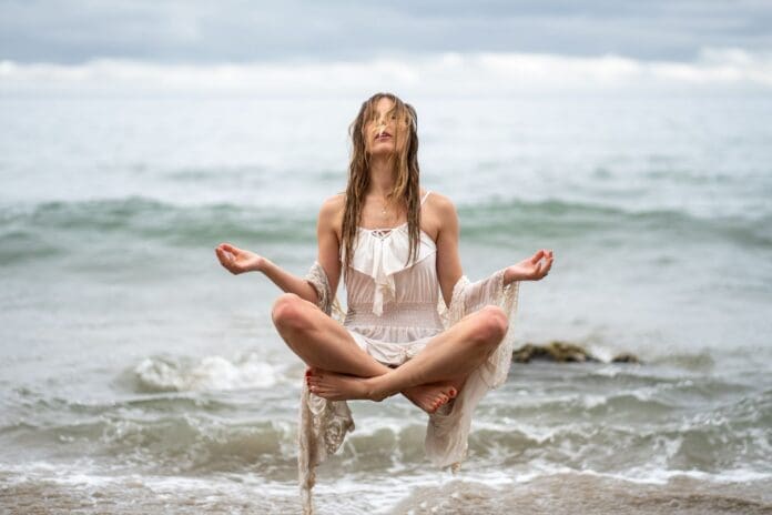 Video of a woman meditating in the ocean.