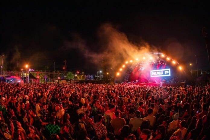 A large crowd at the III Points music festival at night, excitedly anticipating the drop of 2024 dates and the initial ticket sale in Miami.