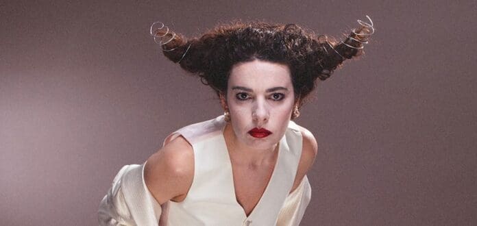 A woman in a white dress with horns on her head releases infectious pop anthem 