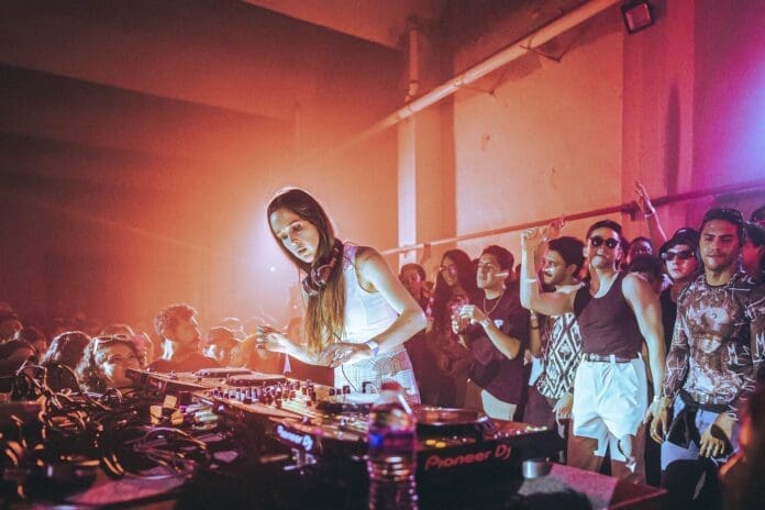 A woman DJing in front of a crowd in Mexico City.