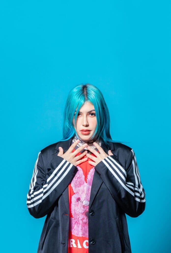 A woman with blue hair on a blue background.