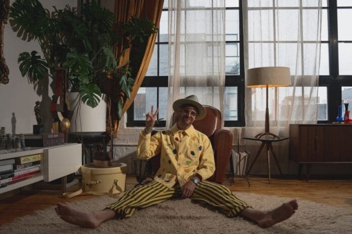 A man sitting on a rug in a living room experiences Nitefreak & friends' Tomorrowland Music debut with 