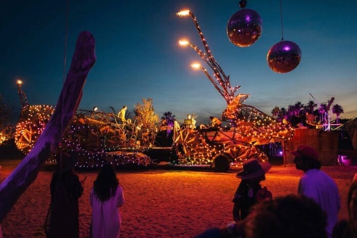 A group of people standing around a float at night during a New Year's Eve celebration in Cabo.