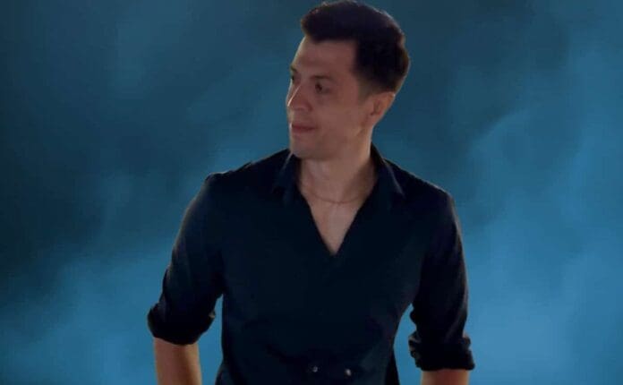 A man wearing a black shirt stands in front of a blue background as Sander Wilder unveils his new single, 'Into The Abyss'.