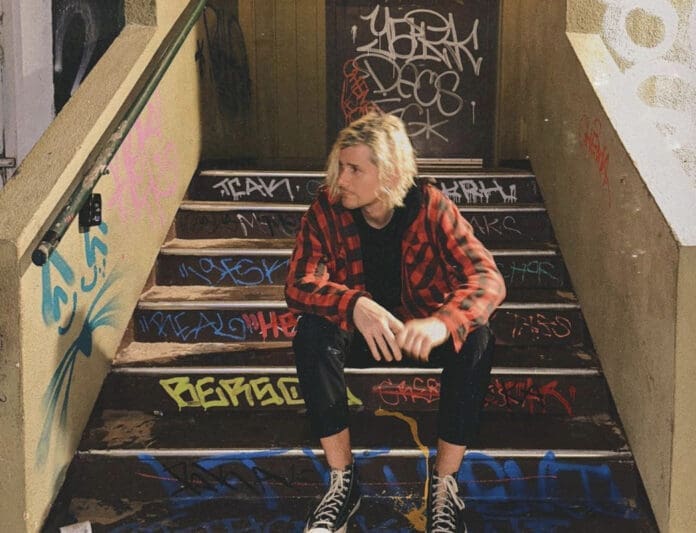 A man sitting on a set of stairs covered in graffiti, captured in a masterful photograph.