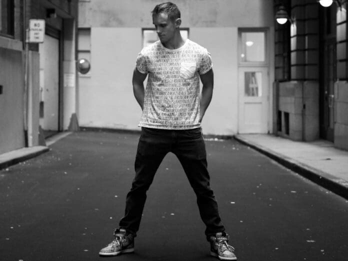 A man in a t-shirt standing in an funky alleyway for Halloween.