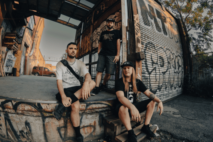 A group of young men sitting in front of a graffiti covered building.