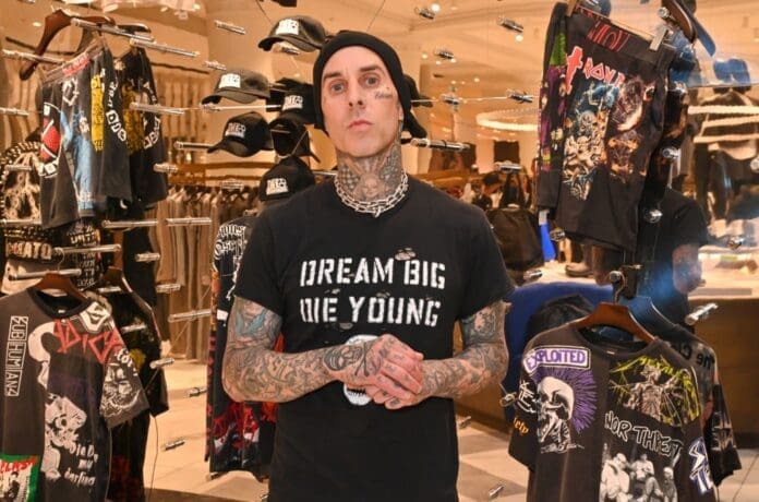 A man in front of a t-shirt rack.