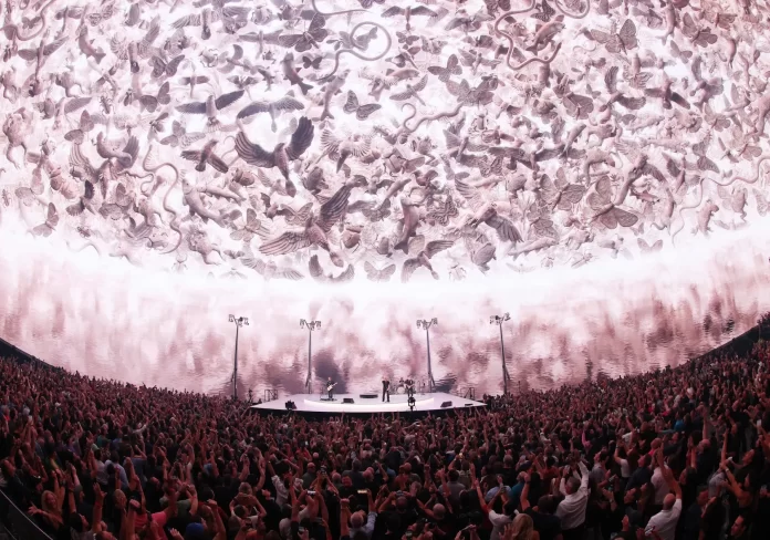 A large crowd of people enjoying an entertaining show at a dome.