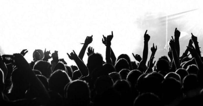 A black and white photo of a crowd at a concert, depicting the vibrant nightlife scene in the UK.