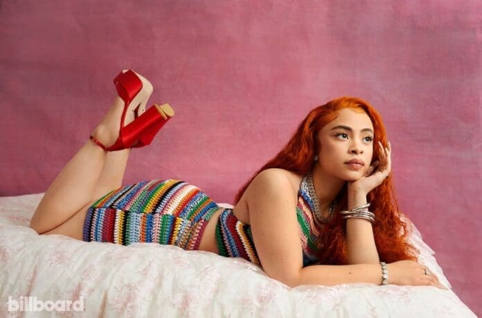 A woman in a vibrant dress lounging on a bed.