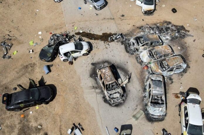 An aerial view of burnt out cars in a desert after a supernatural event.