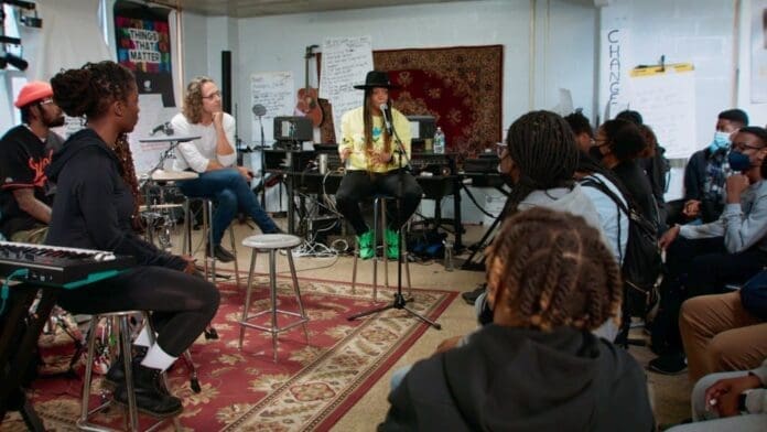 A group of people in a room listening to music while watching the 'Stand Up & Shout' trailer from the John Legend-produced HBO documentary.