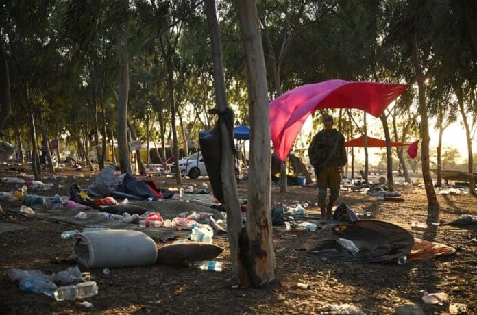 Survivors standing under a tent in the woods at Nova Festival.