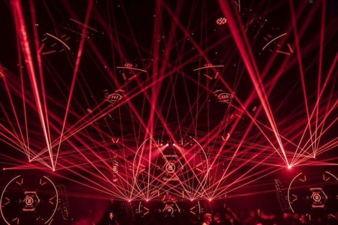 A red laser light illuminates a dark room during the Resistance Miami show.