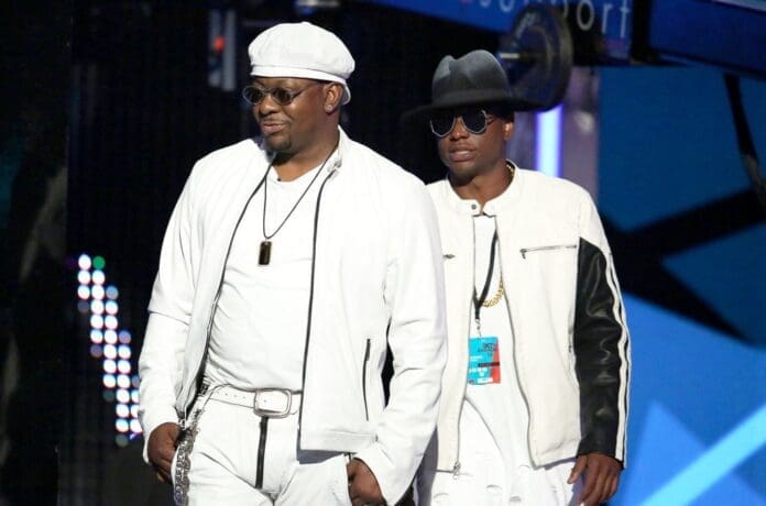 Bobby Brown standing next to a late son in a white outfit in a photo.