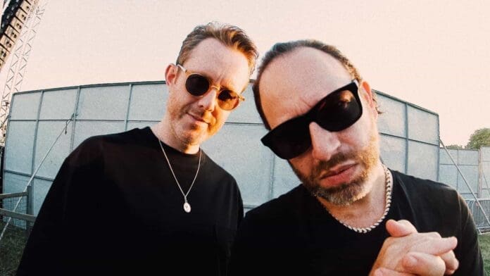 Two men in sunglasses standing next to each other, promoting the latest album by Chase & Status.