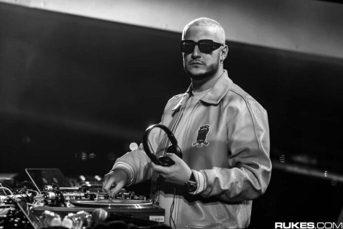 A black and white photo of DJ Snake, collaborating with BTS member Jung Kook, as they both wear sunglasses.