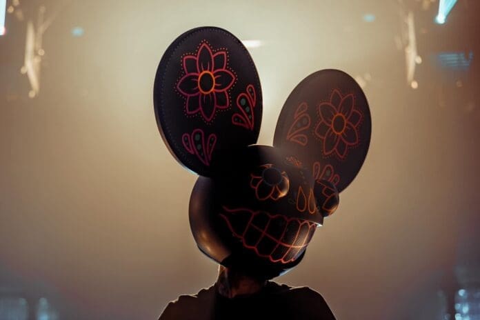 A person wearing a mickey mouse mask in front of a light at the Red Rocks Preview.