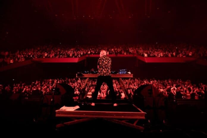 A dj standing in front of a crowd of people at MIDƐM+ in Cannes, 2024.