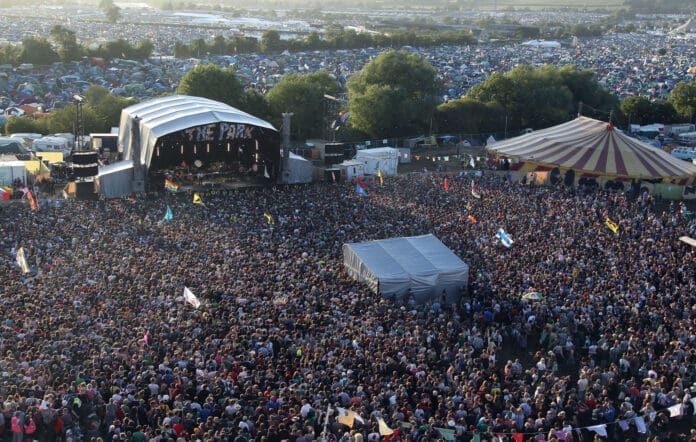 An aerial view of a large crowd at the Glastonbury music festival.